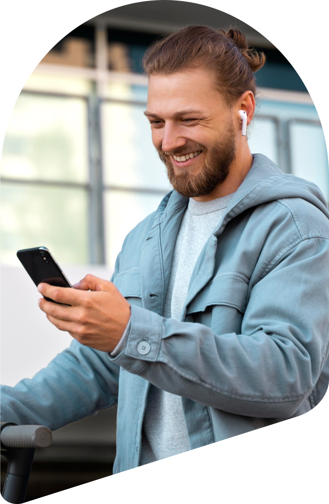 A man is checking his mobile device while smiling